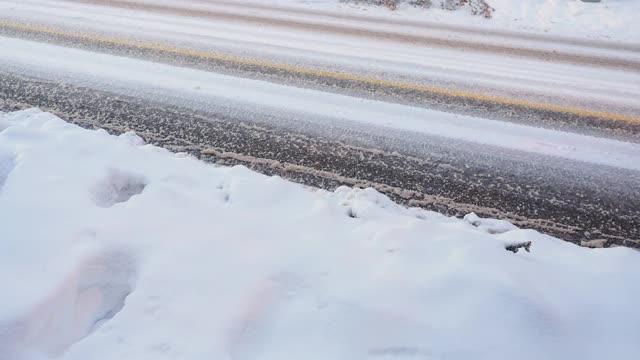 大雪过后，汽车在覆盖着积雪的城市街道上行驶视频素材