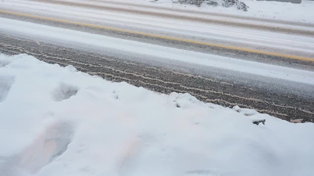 大雪过后，汽车在覆盖着积雪的城市街道上行驶视频素材