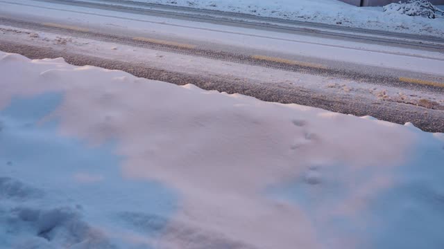 大雪过后，汽车在覆盖着积雪的城市街道上行驶视频素材