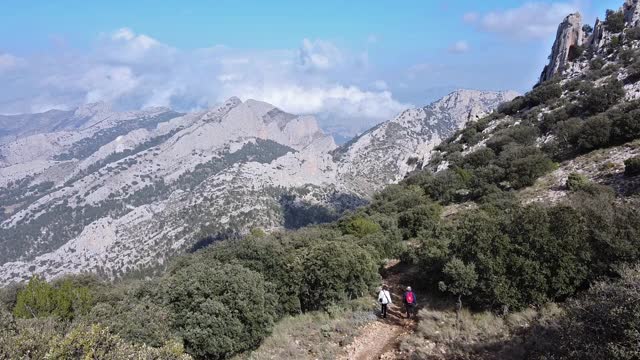 两个徒步旅行者在一座落基山的山顶上行走视频素材