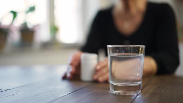 年长的女人坐下来吃药视频素材