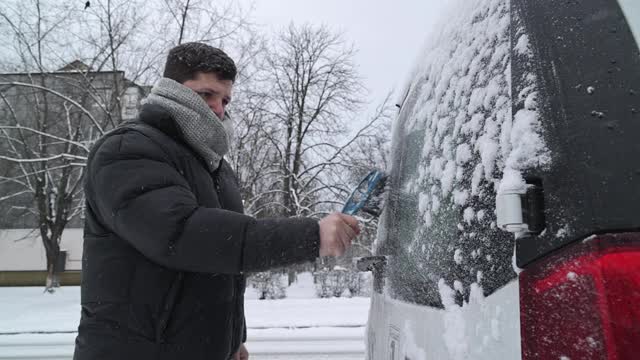 一场大雪过后，司机把车上的积雪清理干净。视频素材