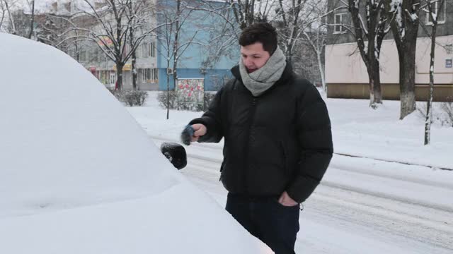 一场大雪过后，司机把车上的积雪清理干净。视频素材