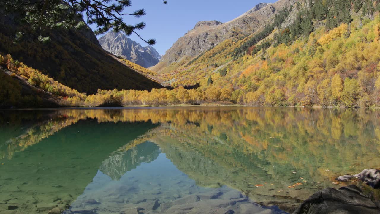 山上有晶莹的湖水和五颜六色的黄色树木。视频素材