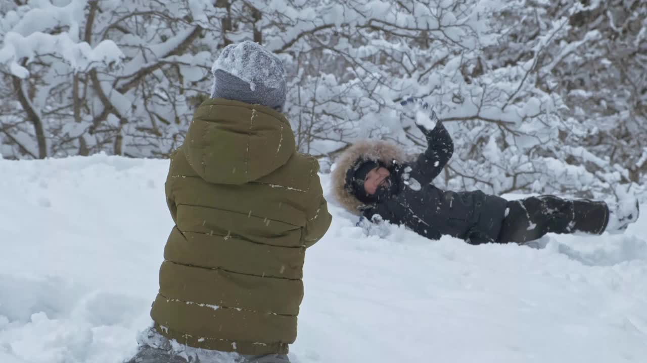 男孩和朋友们在冬天的公园里玩雪视频素材