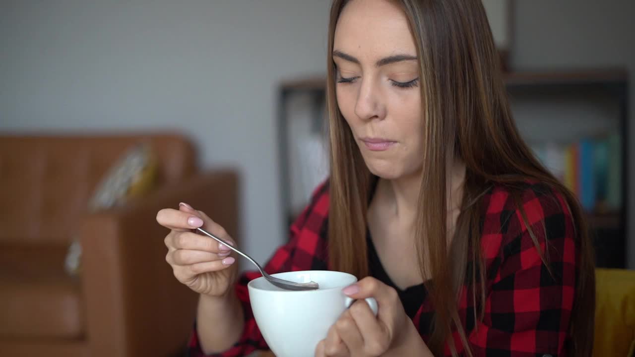 美丽的年轻女子吃一碗健康的格兰诺拉麦片视频素材