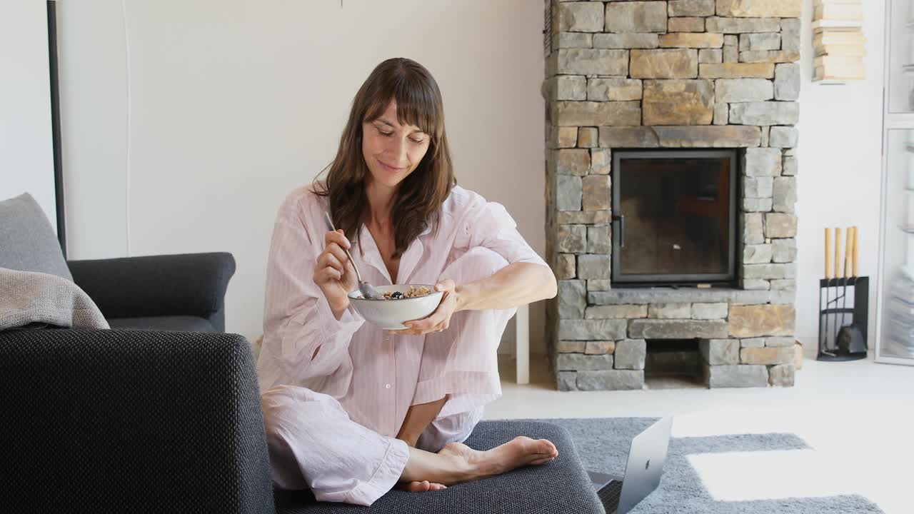 女人在家吃麦片，享受早晨视频素材