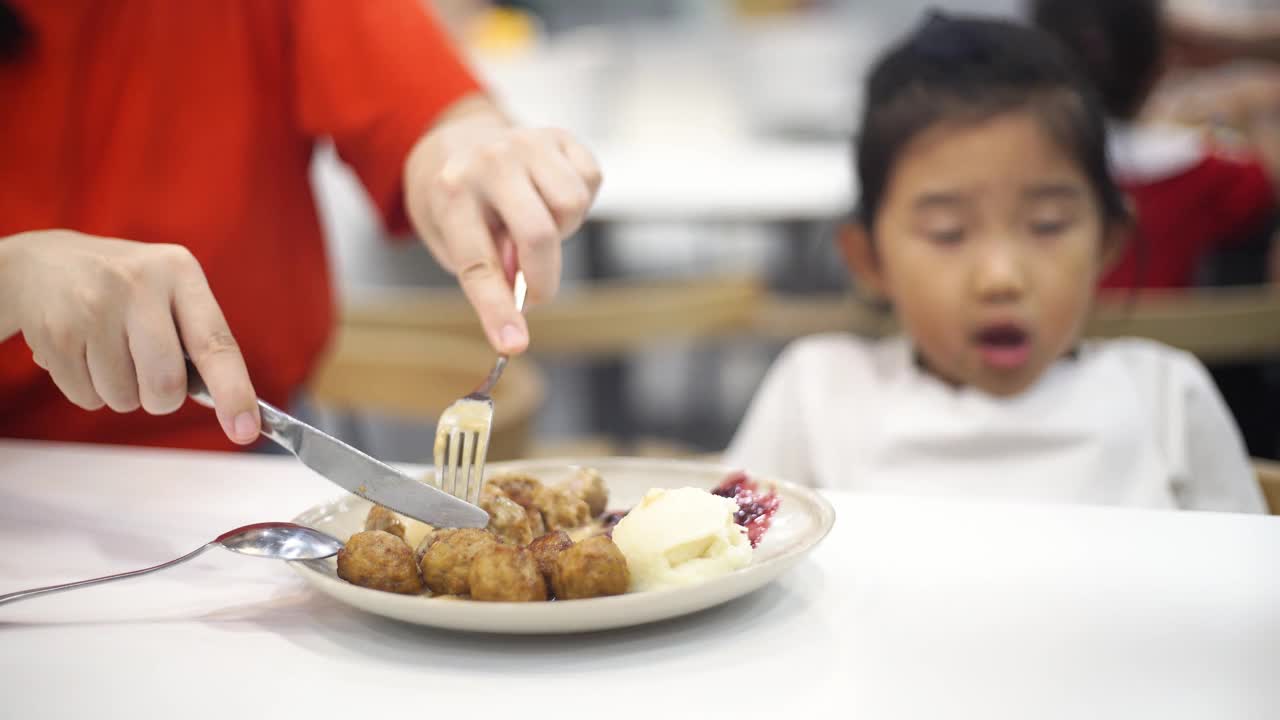 母亲帮助女儿分食物视频素材