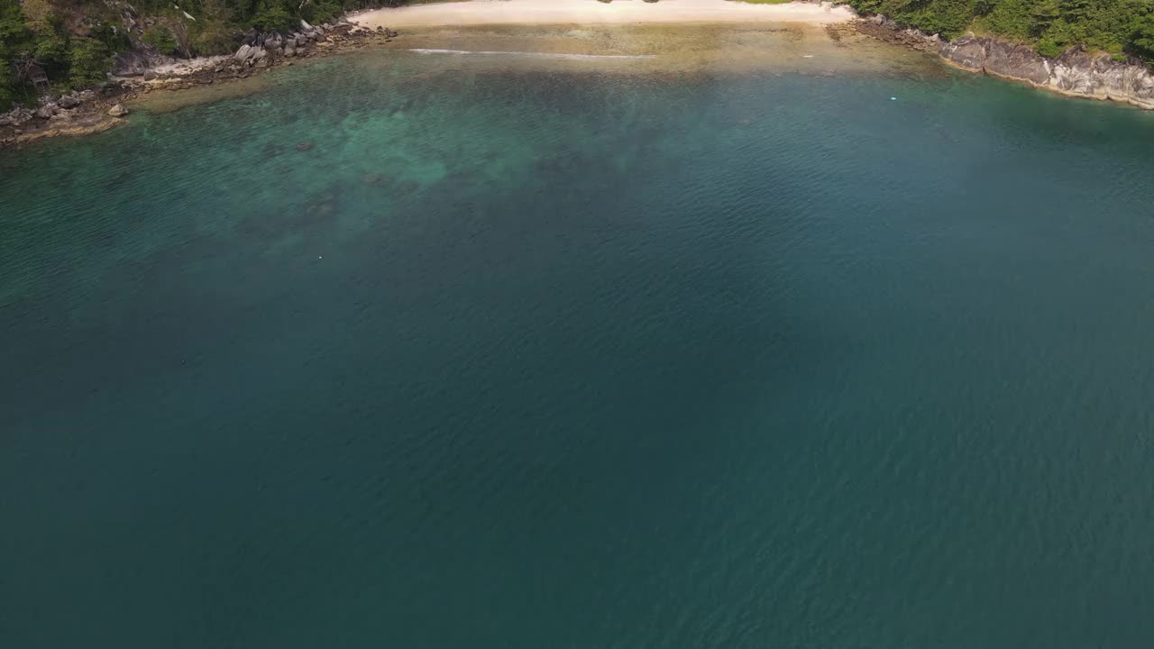 无人机俯瞰海洋和海滩岩石的鸟瞰图，泰国飞行在清澈的蓝色海水上方令人惊讶的低航拍海面。股票视频视频素材