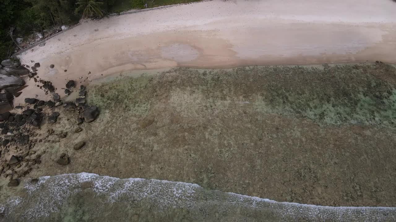 无人机俯瞰海洋和海滩岩石的鸟瞰图，泰国飞行在清澈的蓝色海水上方令人惊讶的低航拍海面。股票视频视频素材