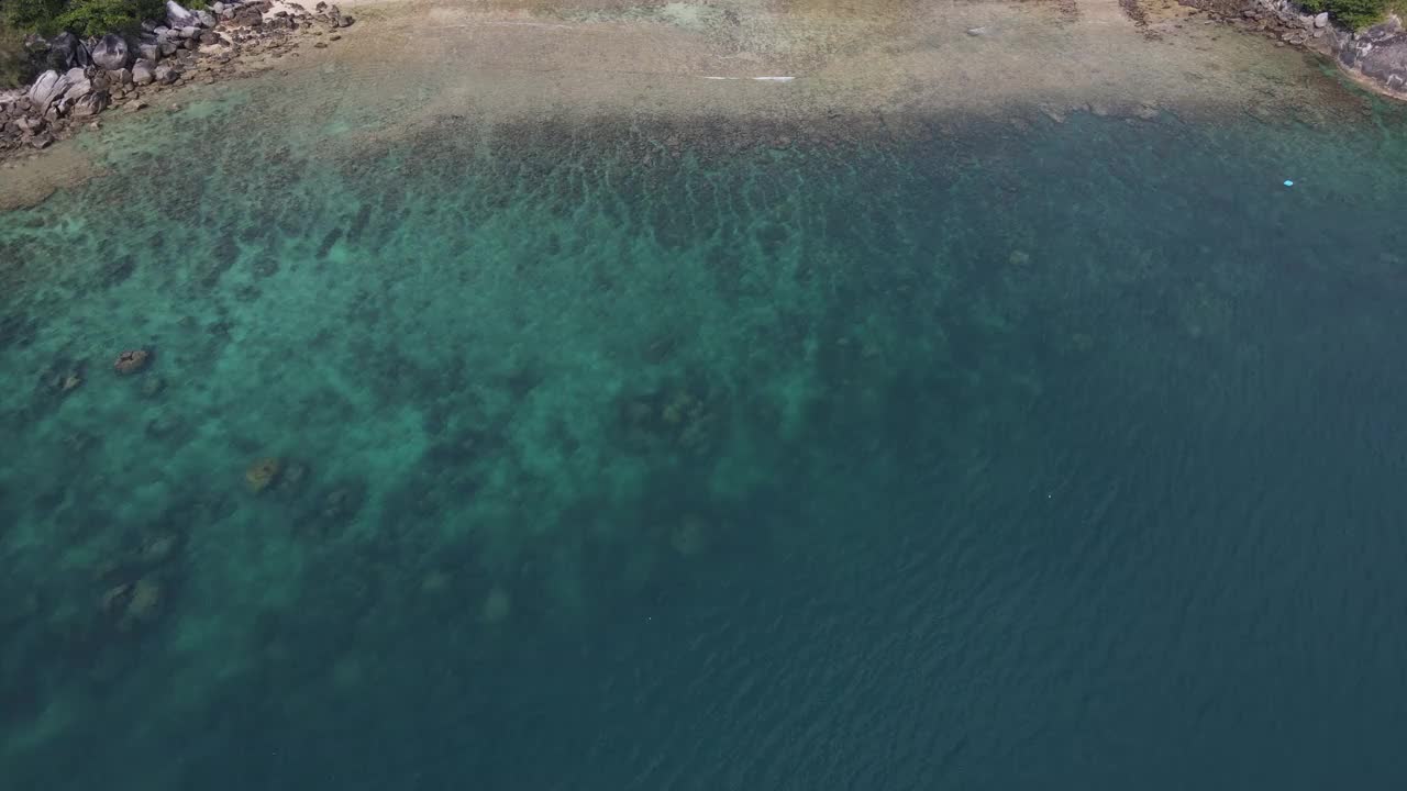 无人机俯瞰海洋和海滩岩石的鸟瞰图，泰国飞行在清澈的蓝色海水上方令人惊讶的低航拍海面。股票视频视频素材