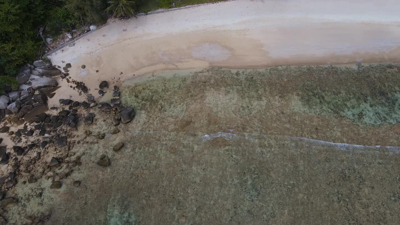 无人机俯瞰海洋和海滩岩石的鸟瞰图，泰国飞行在清澈的蓝色海水上方令人惊讶的低航拍海面。股票视频视频素材