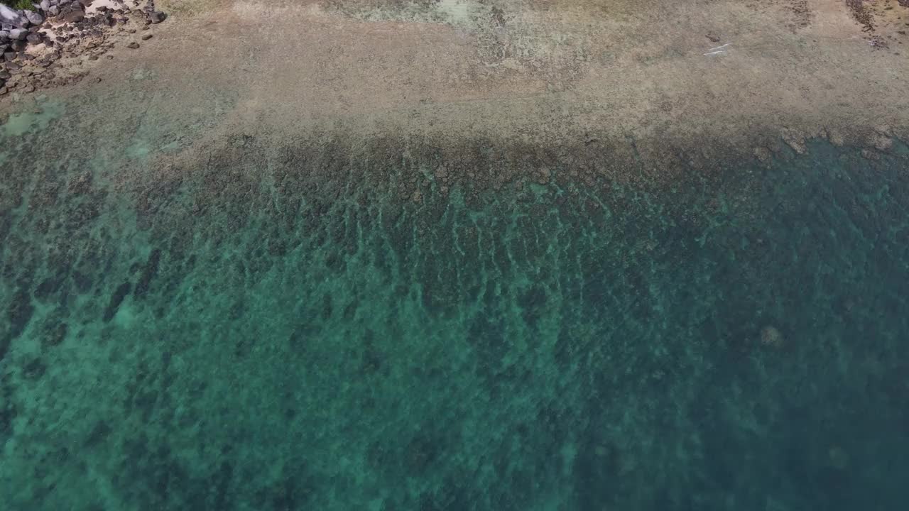 无人机俯瞰海洋和海滩岩石的鸟瞰图，泰国飞行在清澈的蓝色海水上方令人惊讶的低航拍海面。股票视频视频素材