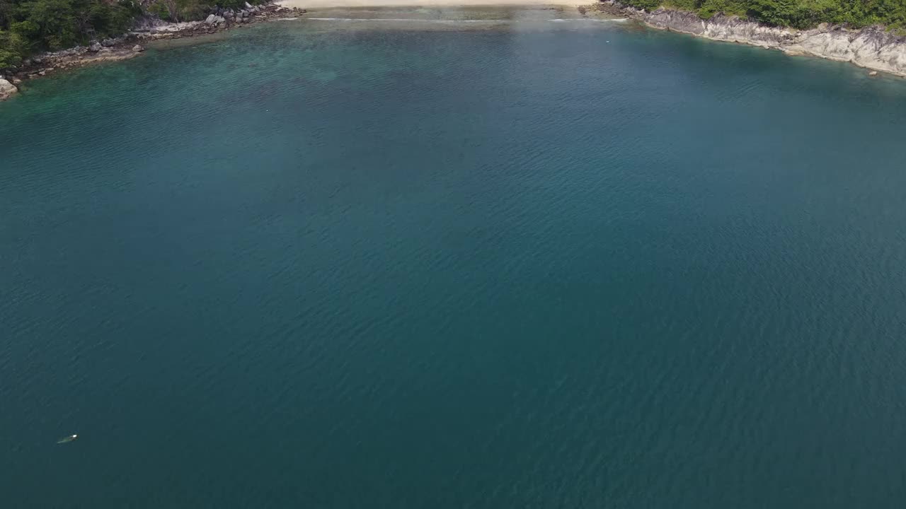 无人机俯瞰海洋和海滩岩石的鸟瞰图，泰国飞行在清澈的蓝色海水上方令人惊讶的低航拍海面。股票视频视频素材