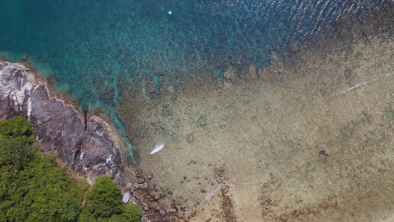 无人机俯瞰海洋和海滩岩石的鸟瞰图，泰国飞行在清澈的蓝色海水上方令人惊讶的低航拍海面。股票视频视频素材