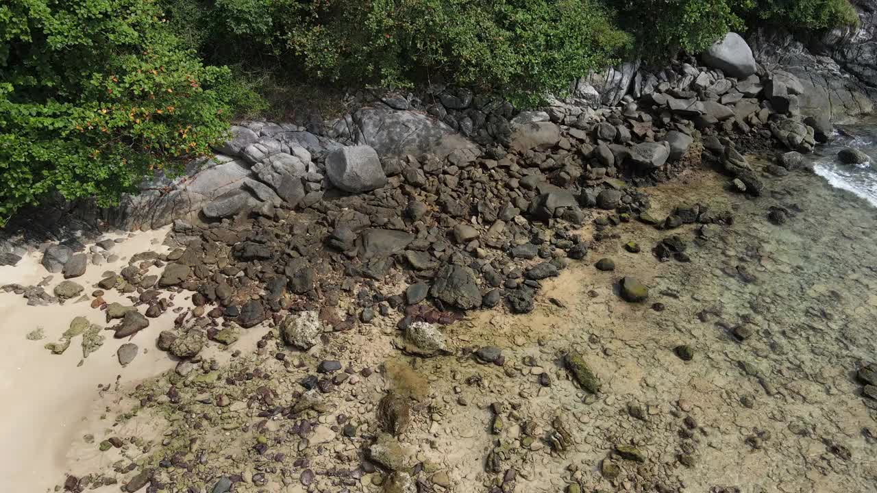 无人机俯瞰海洋和海滩岩石的鸟瞰图，泰国飞行在清澈的蓝色海水上方令人惊讶的低航拍海面。股票视频视频素材