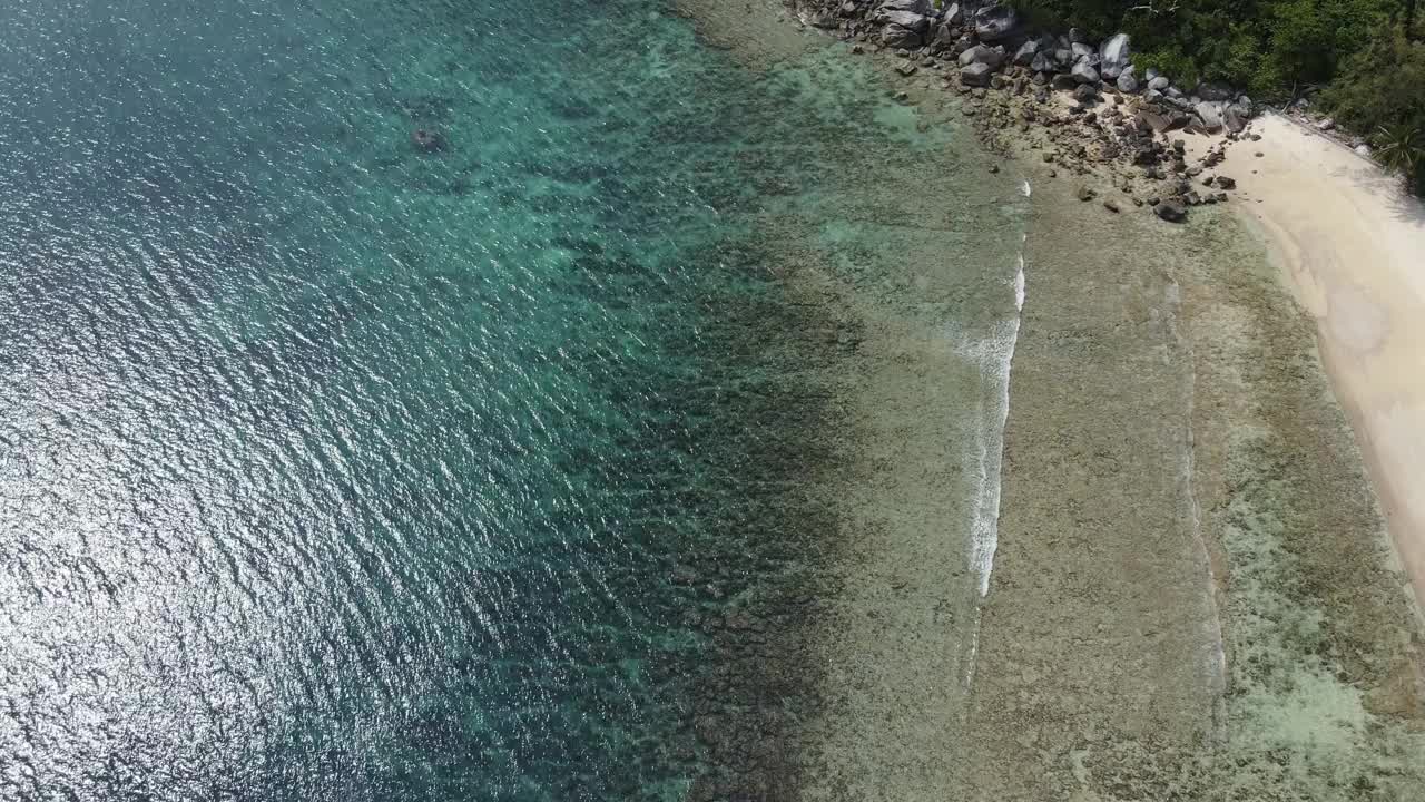 无人机俯瞰海洋和海滩岩石的鸟瞰图，泰国飞行在清澈的蓝色海水上方令人惊讶的低航拍海面。股票视频视频素材