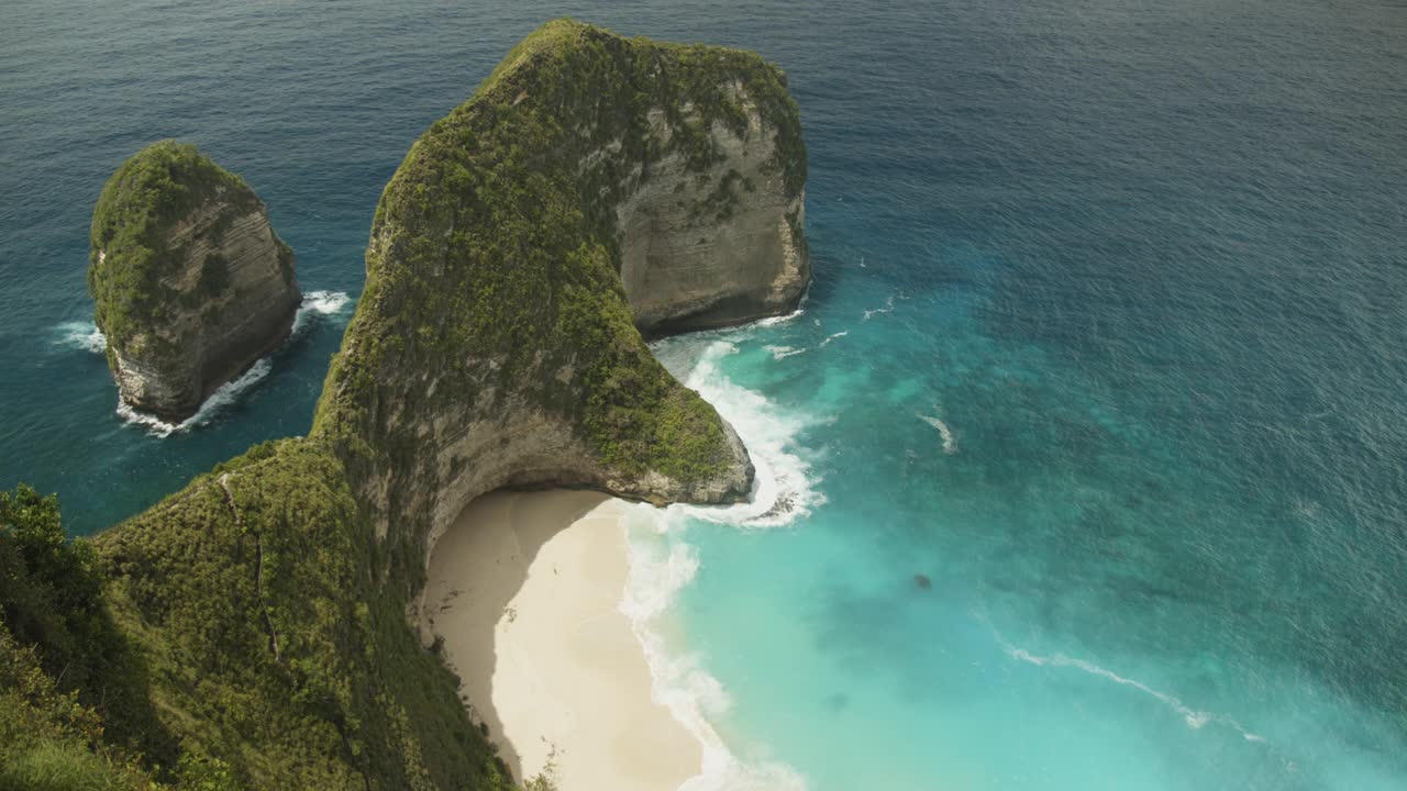 静态慢动作拍摄的海浪冲击在令人惊叹的热带海滩克林金海滩和霸王龙湾在巴厘岛，印度尼西亚与绿松石蓝色的水和沙滩从上面视频素材