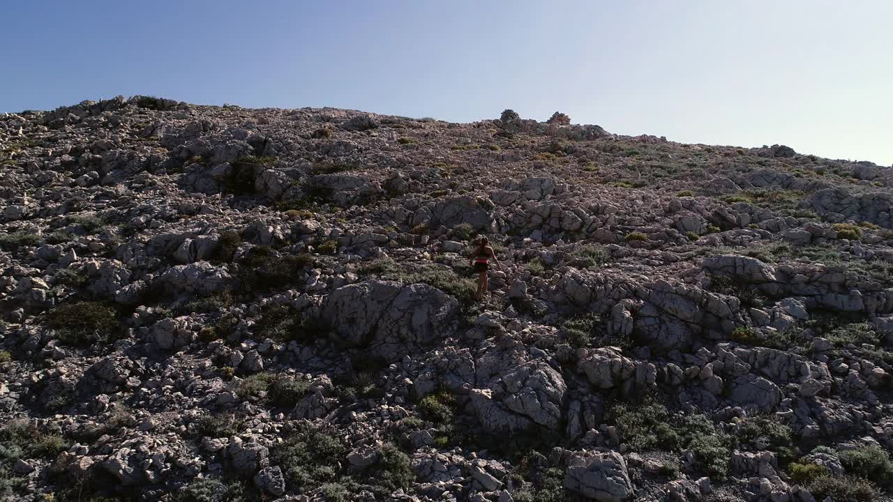 一名年轻女子正在爬一座地势极端的山视频素材