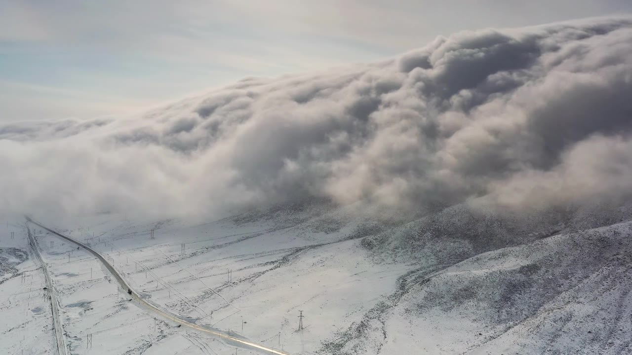 云瀑从山顶倾泻而下，淹没了山谷的道路视频素材画面1