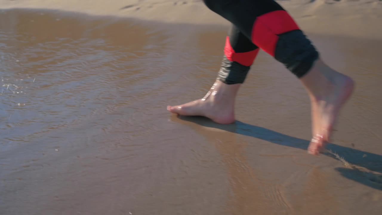 在海滩上赤脚行走的女人视频素材