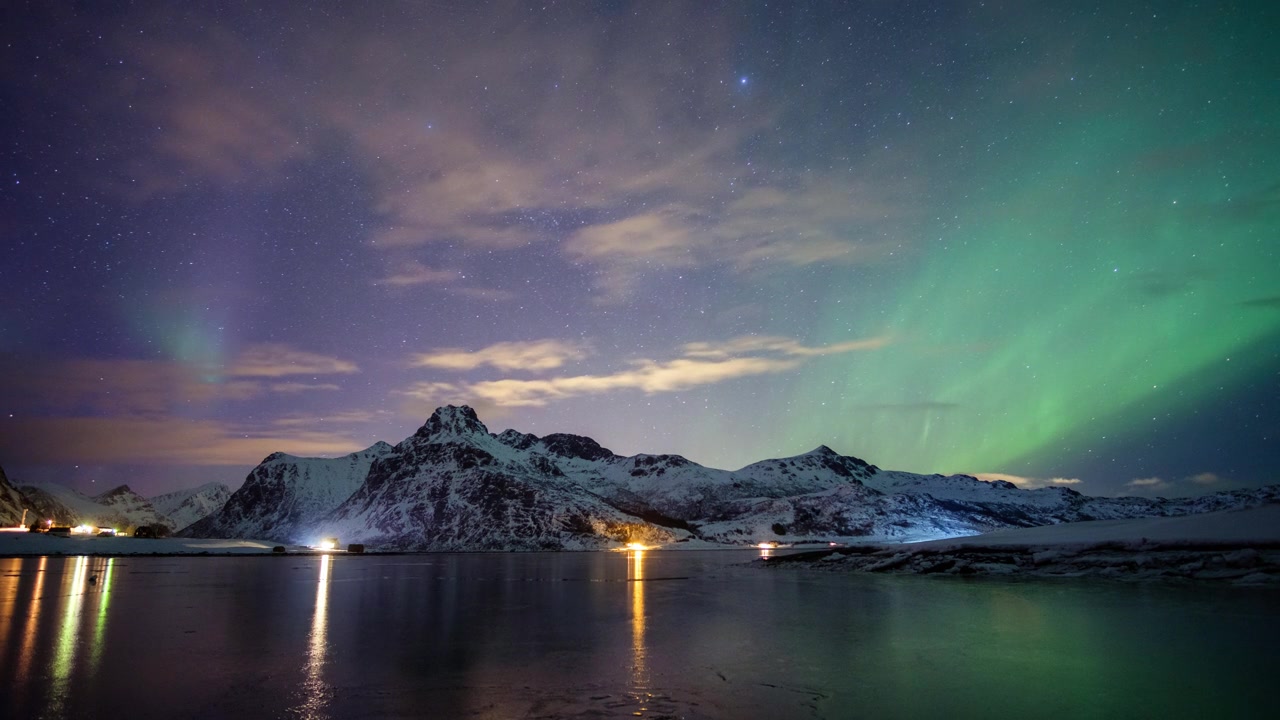 北极光吹过挪威罗浮敦群岛Flakstad海岸线上的雪山视频素材画面3