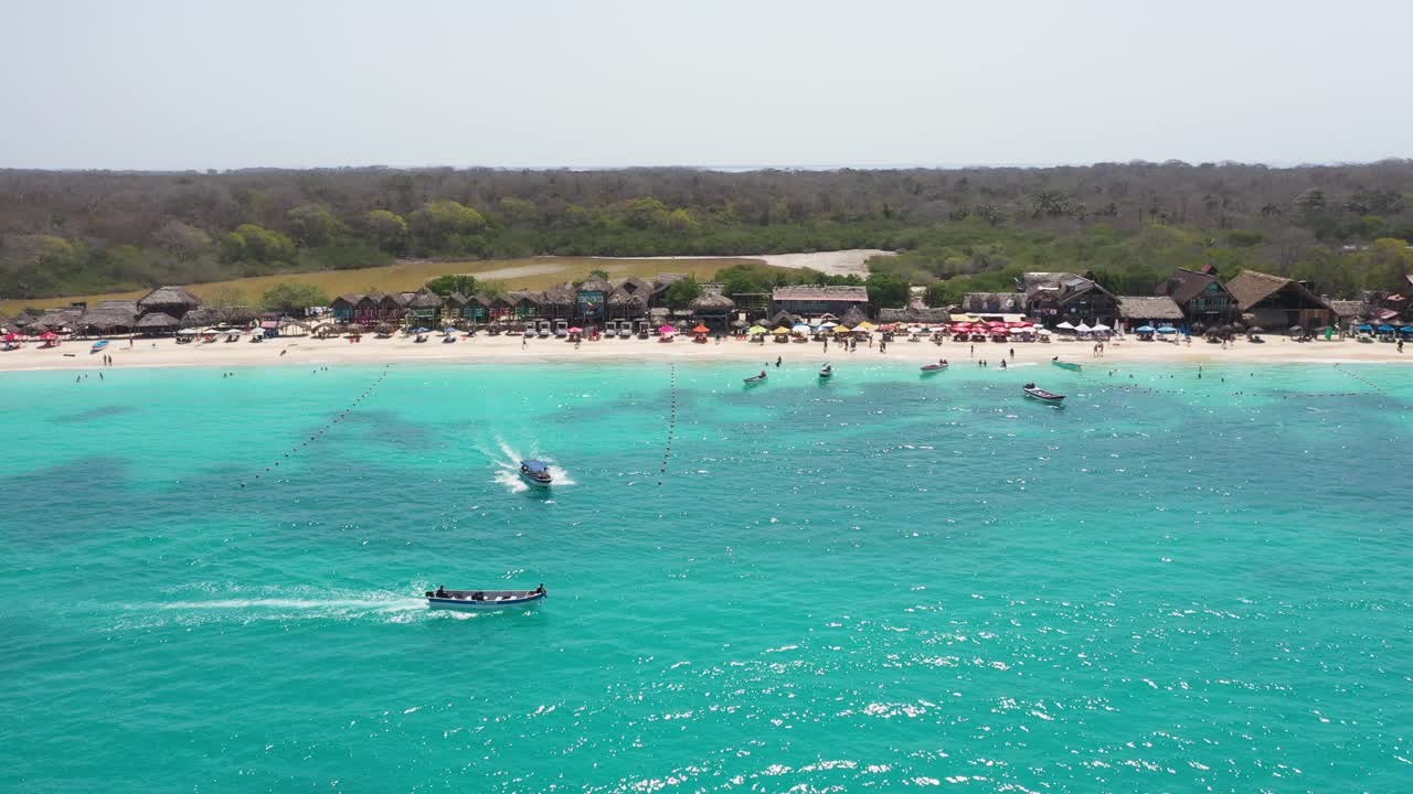 一艘游船带着游客沿着热带海滩的空中全景游览视频素材