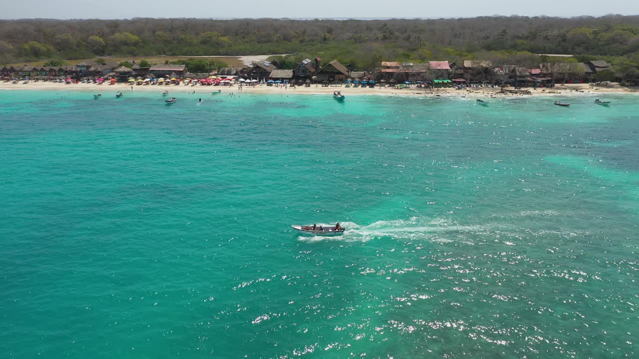 一艘游船带着游客沿着热带沙滩的鸟瞰图进行短途旅行视频素材