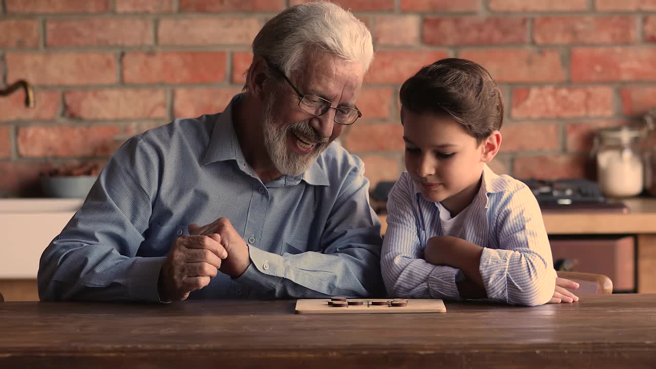 快乐的老人和小孙子下棋。视频素材