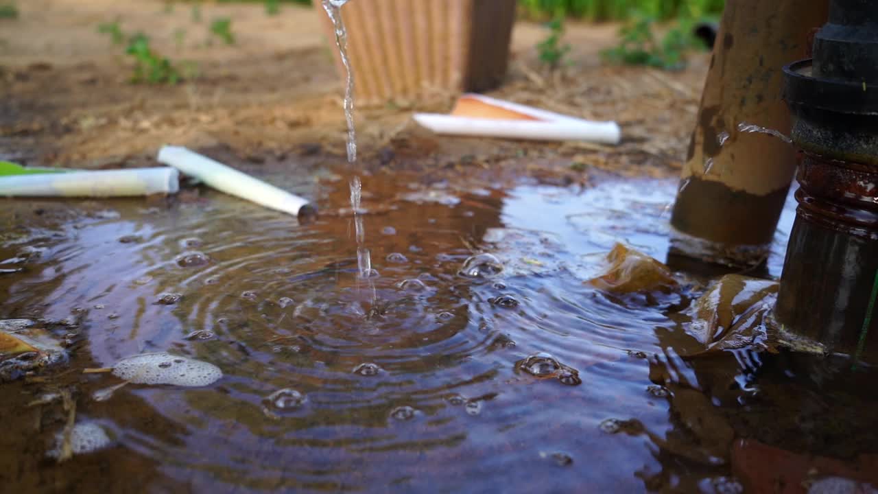 水从塑料管漏出来。很多水聚集在水弯附近。软管连接漏水，喷溅水。视频素材