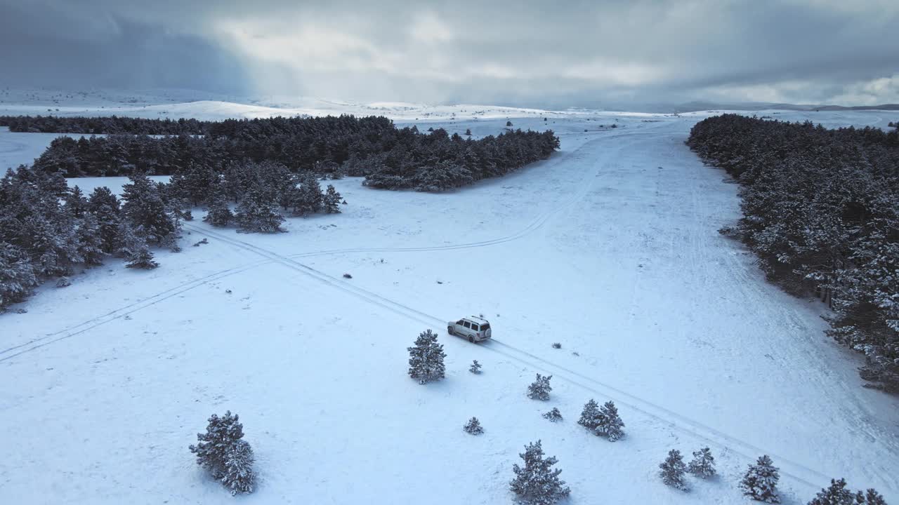 无人机拍摄的越野车行驶在冰雪路面上。视频素材