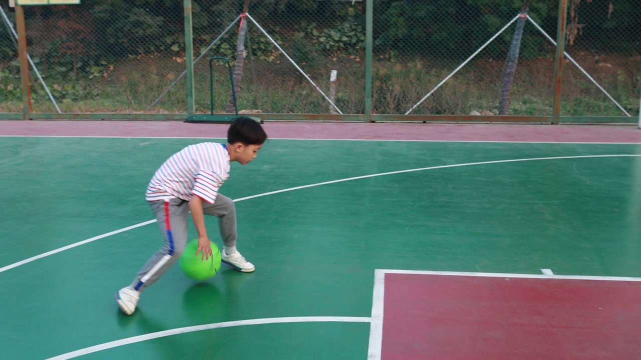 可爱的小男孩在打篮球视频素材画面2