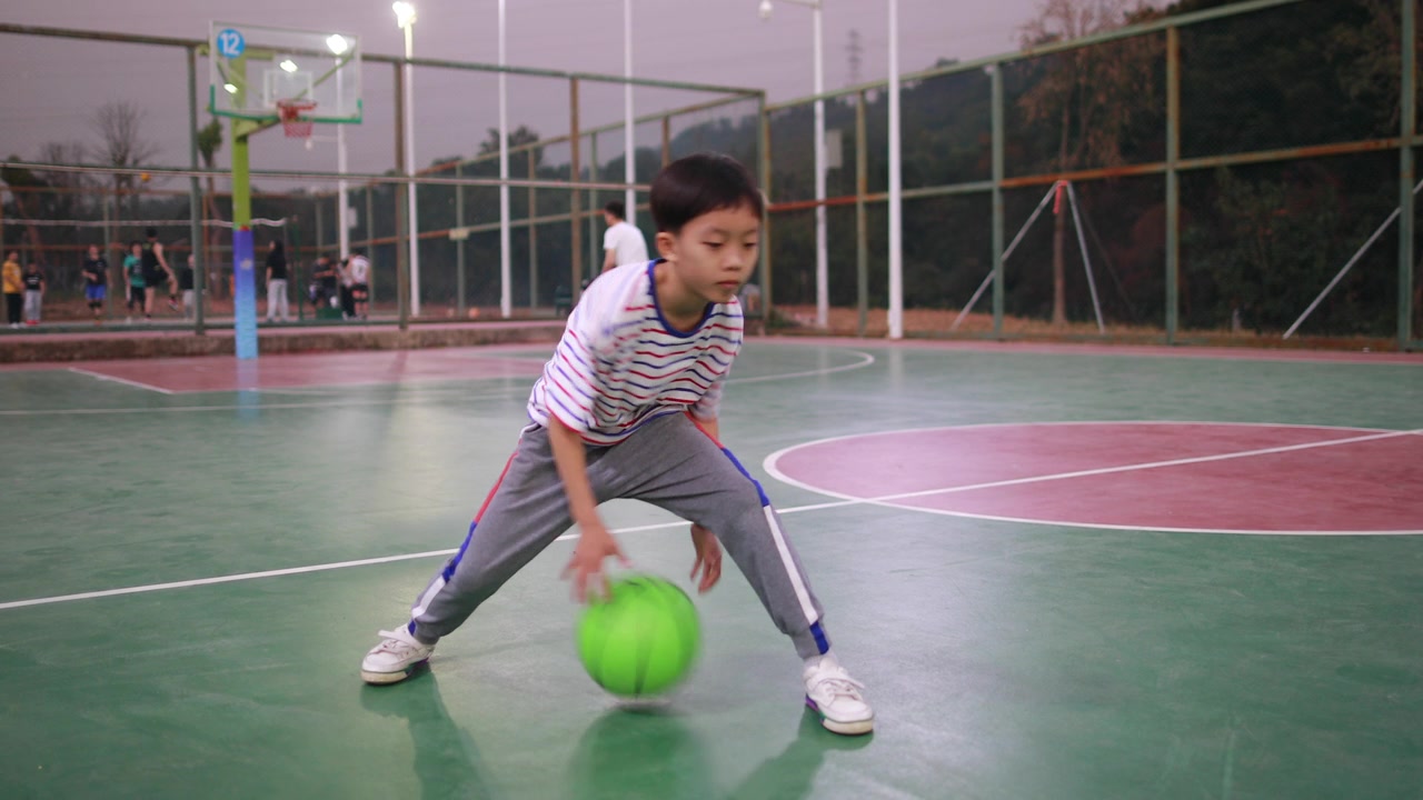 可爱的小男孩在打篮球视频素材画面2