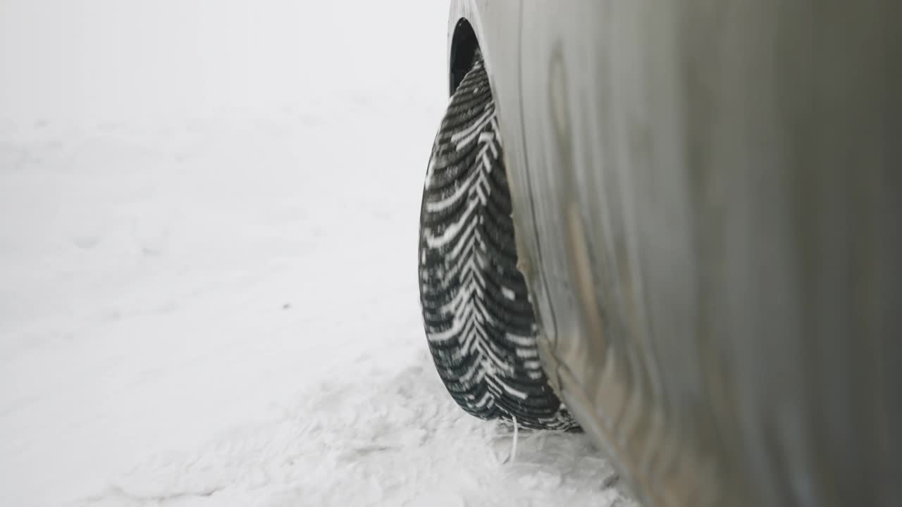 汽车在高速公路上行驶，穿越风雪。飘落的雪路雪花冬天的风暴。一辆雪地轮胎在冬天的路上行驶。冬天雪地上的汽车轮胎视频素材