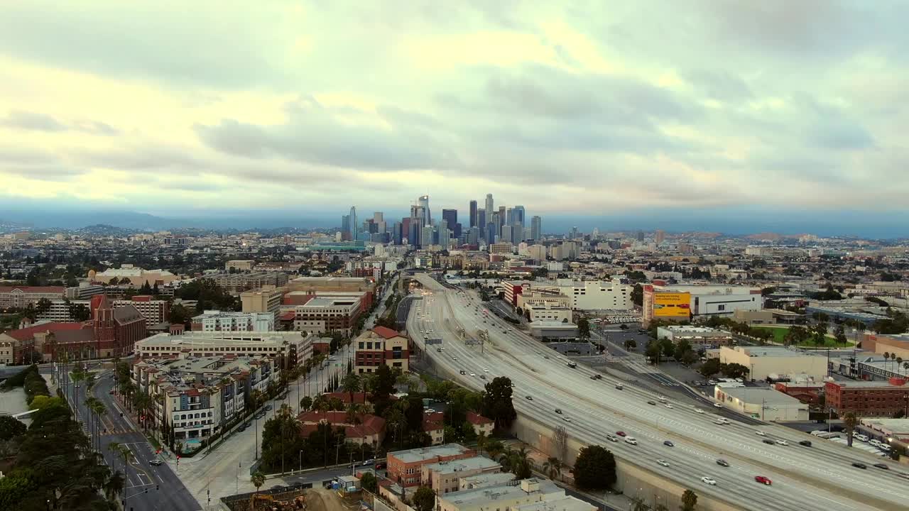 空中时间流逝拍摄的交通在高速公路上对多云的天空在黄昏，无人机向前飞城市-洛杉矶，加利福尼亚州视频素材