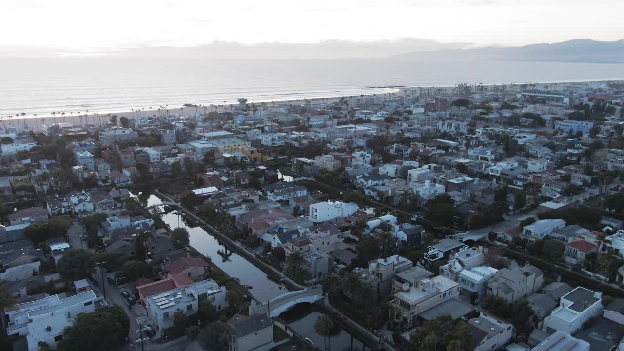 航拍的房子在著名的威尼斯运河对天空，无人机飞向海滩在日落-洛杉矶，加利福尼亚视频素材