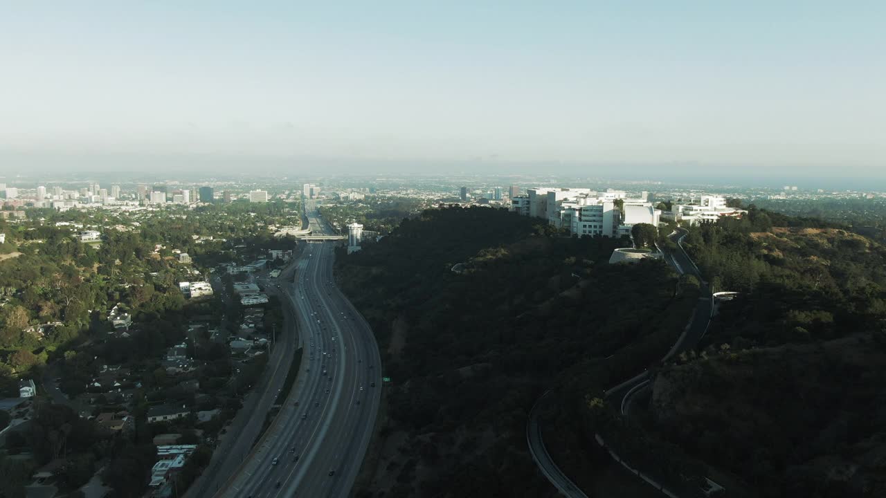 空中拍摄的高速公路上的交通由盖蒂中心对天空，无人机飞向博物馆在日落-洛杉矶，加利福尼亚州视频素材