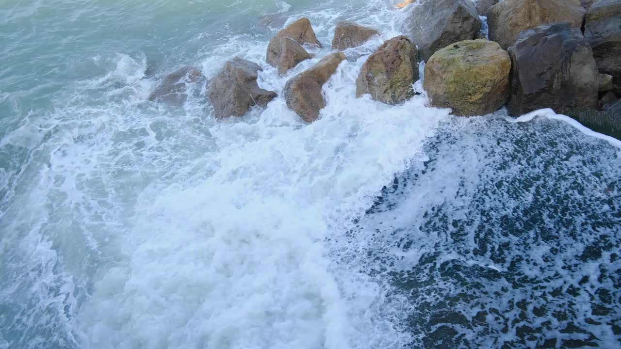 海水溅向岸边的岩石，强大的海浪沉思的奇观，从上面看视频下载