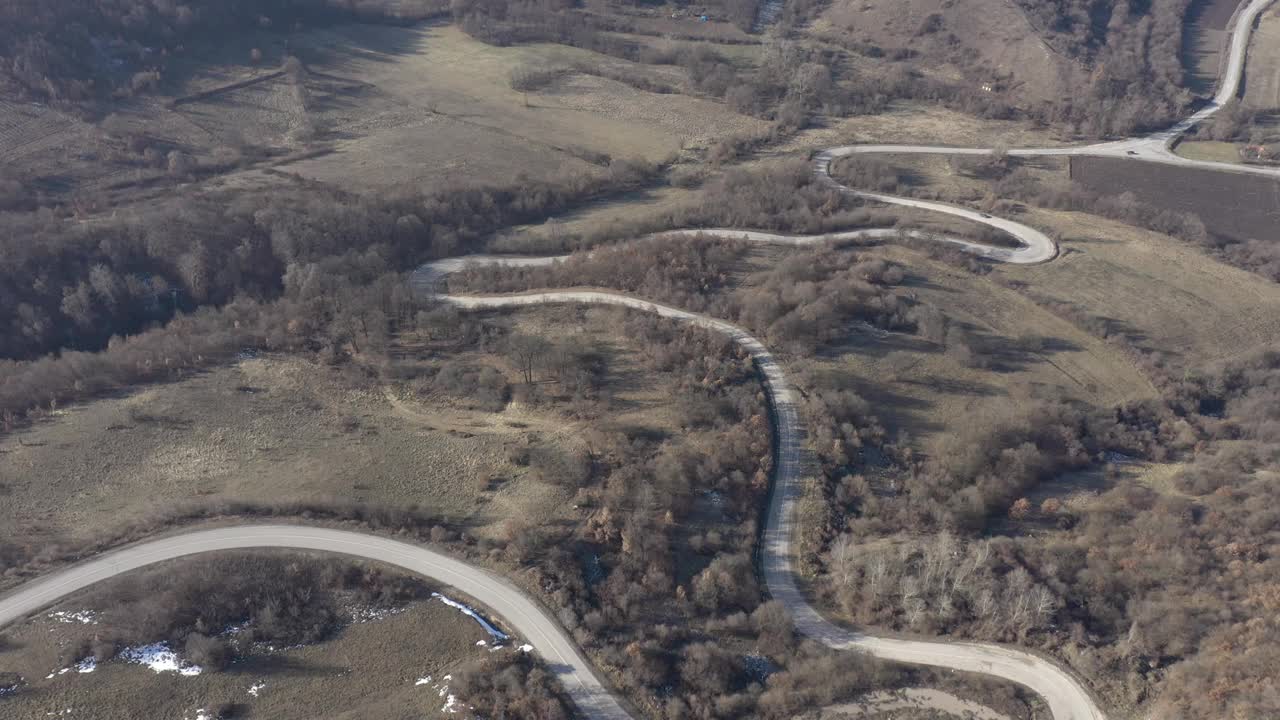 翻越山坡和弯弯曲曲的道路4K航拍画面视频素材