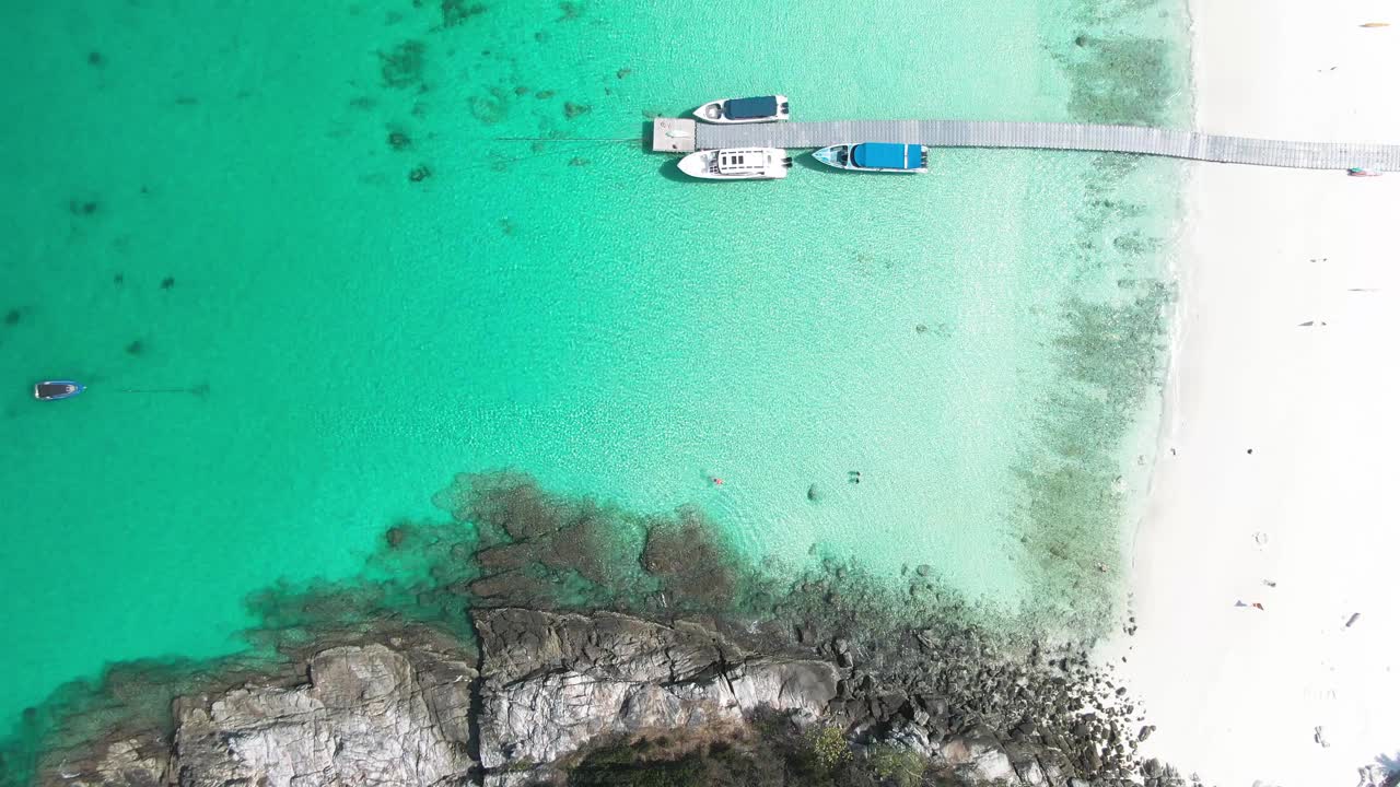 4K镜头鸟瞰图上的船在晴朗的日子水晶清澈的水视频素材