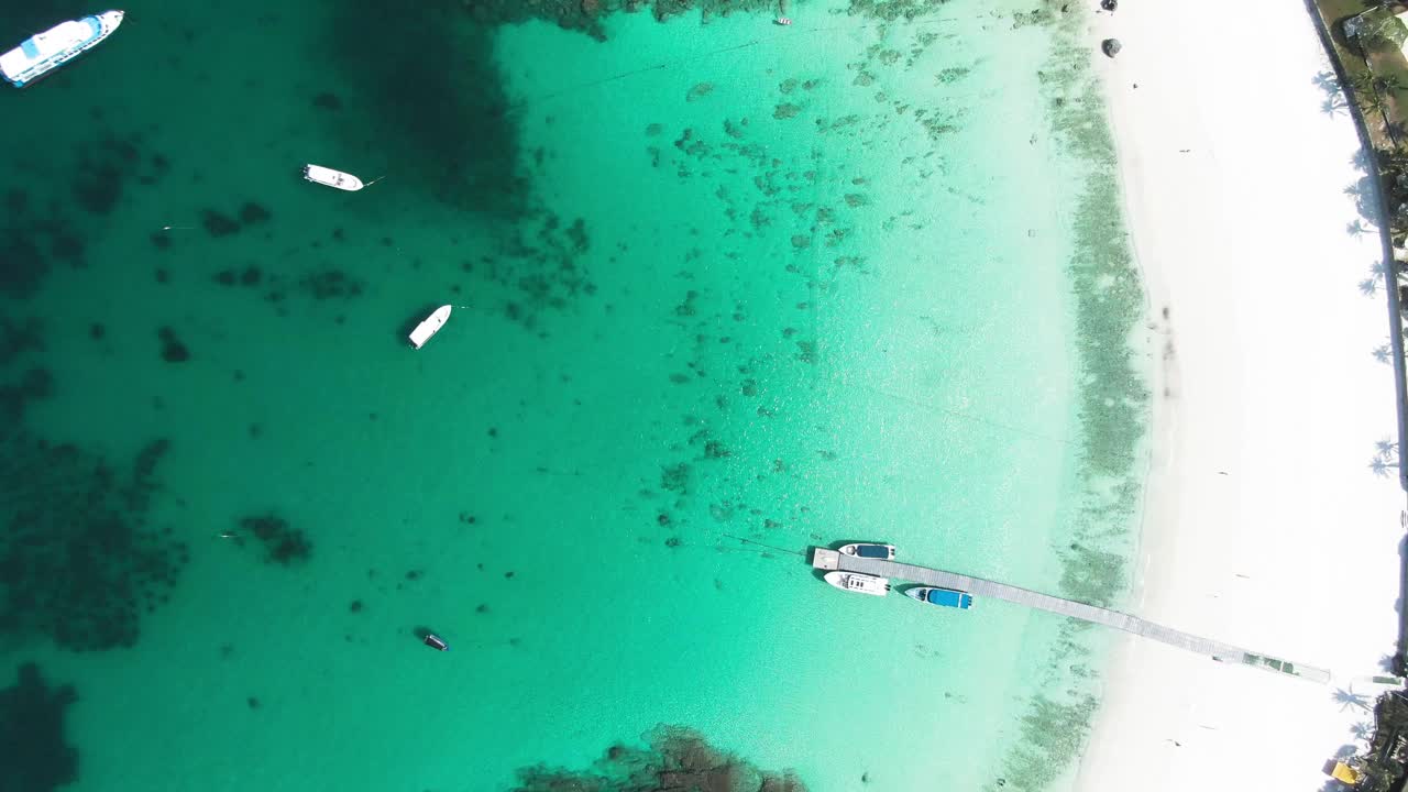 4K镜头鸟瞰图上的船在晴朗的日子水晶清澈的水视频素材