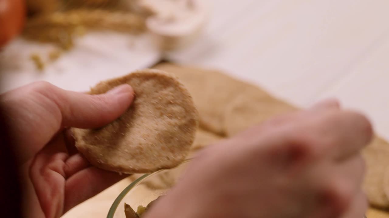 女厨师用手用土豆和蘑菇制作饺子的慢动作。烹饪的过程视频素材