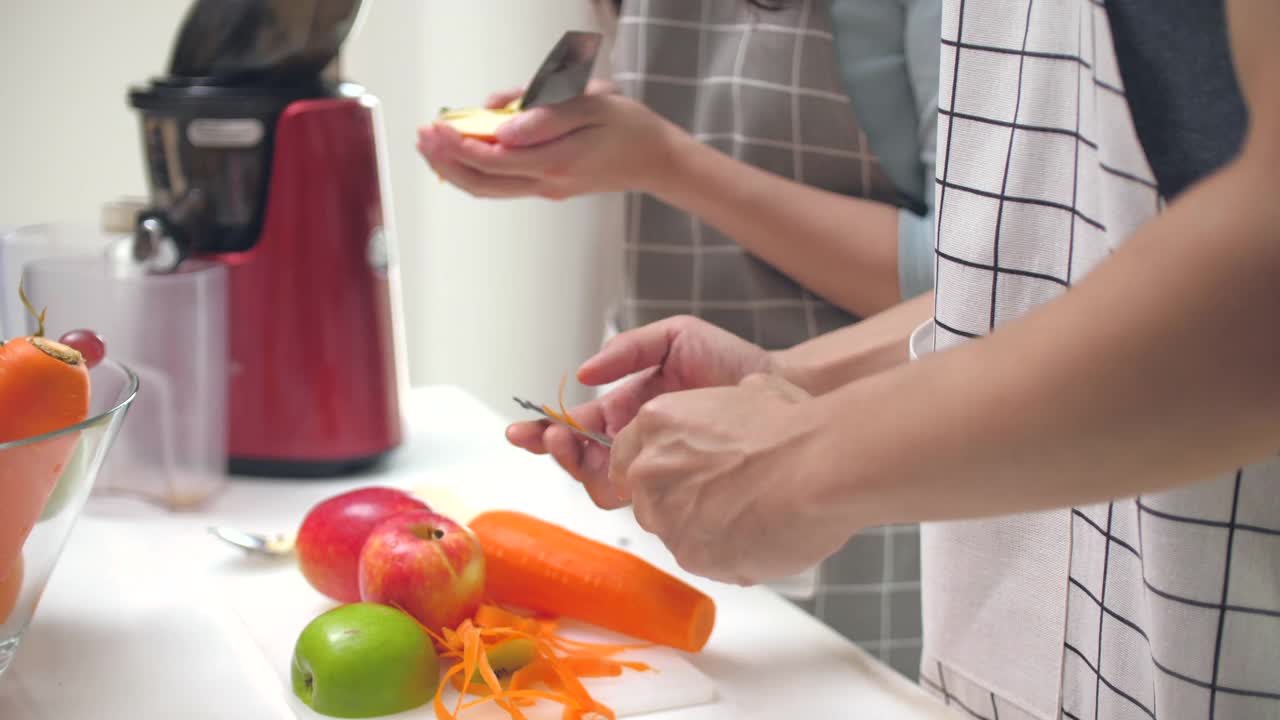 亚洲夫妇准备蔬菜和水果冷榨果汁视频素材