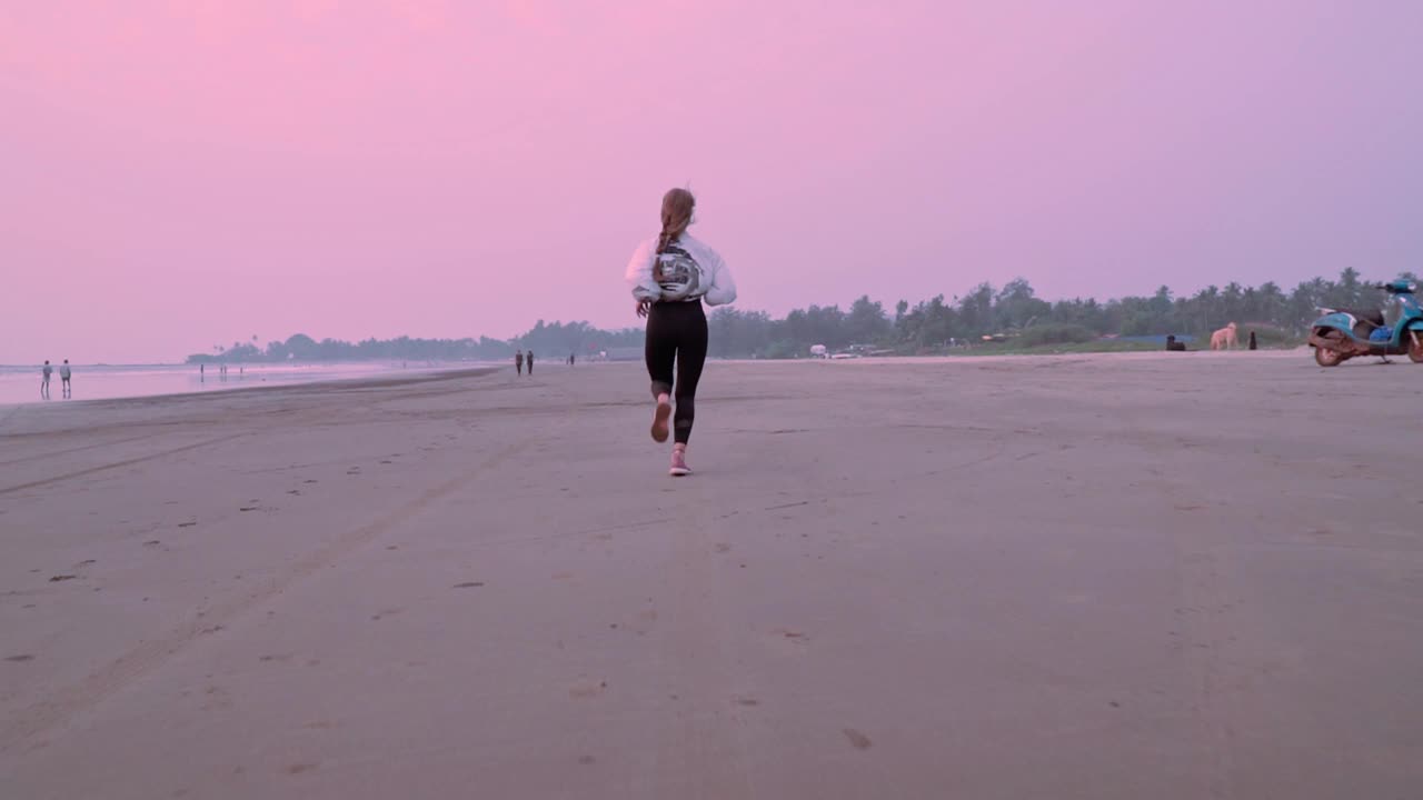 一个女人在海滩上散步视频素材