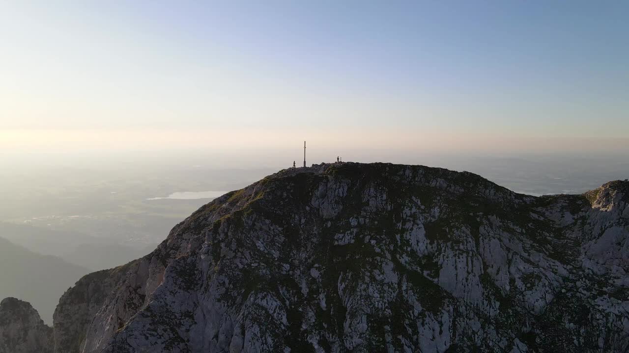 日落时山顶上徒步者的鸟瞰图视频素材