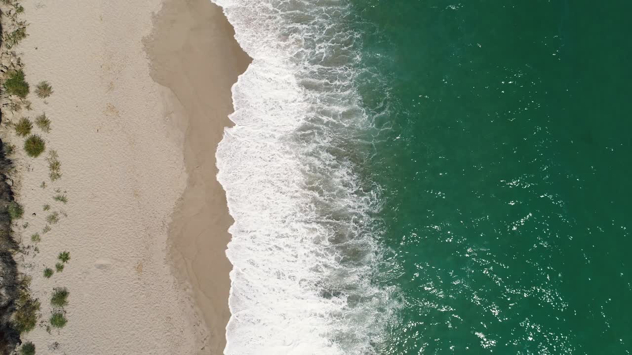 海面日出和溅起的浪花在沙滩上，鸟瞰4k视频视频素材