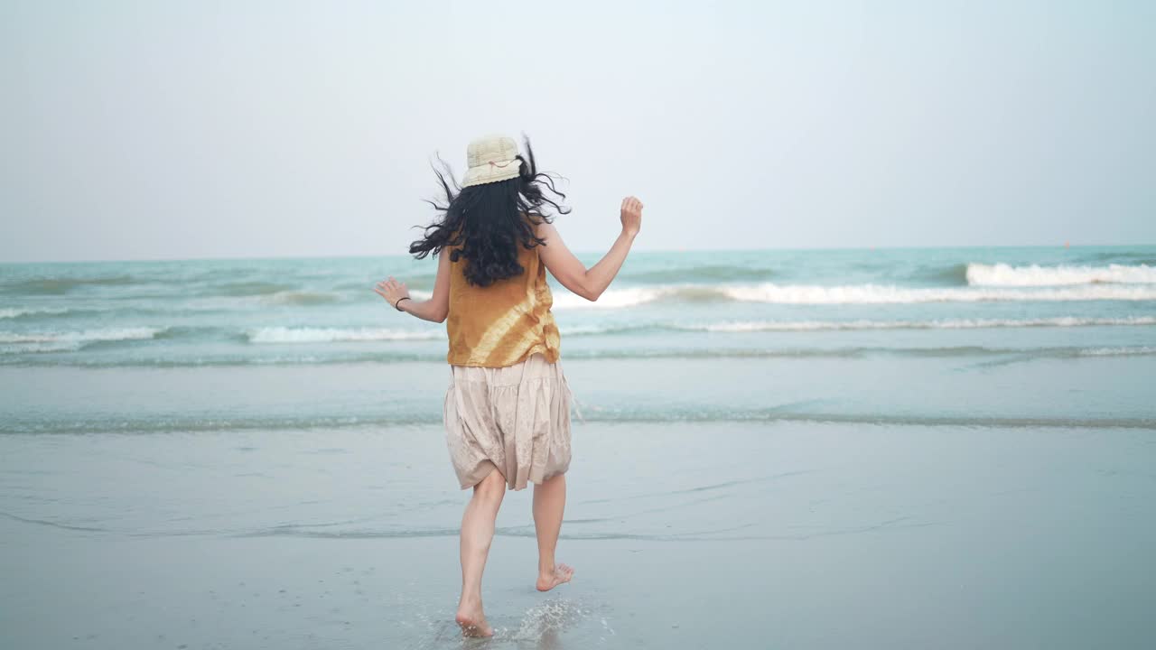 亚洲女人在自由的假期时间快乐和放松的热带san海滩，自然的海滩景观景观与阳光，享受和微笑的乐趣旅游假期，夏日海洋与阳光视频素材