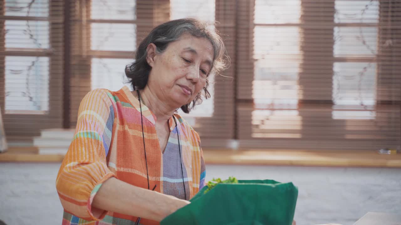 亚洲资深女子从公寓网上购物取出仙人掌视频素材