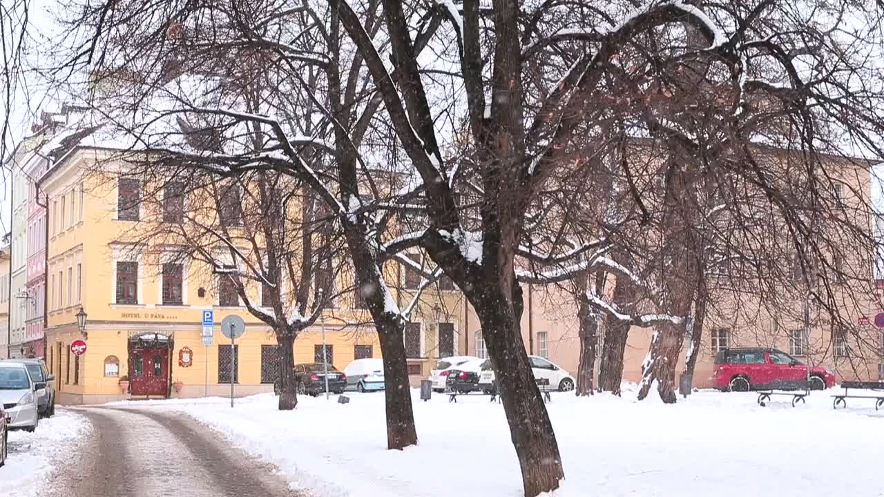 冬天，街上飘着雪花。车停在房子附近。布拉格都市生活。视频素材