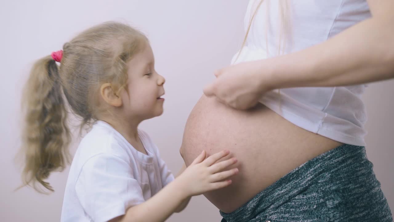 小女孩在家玩孕妇的肚子视频素材